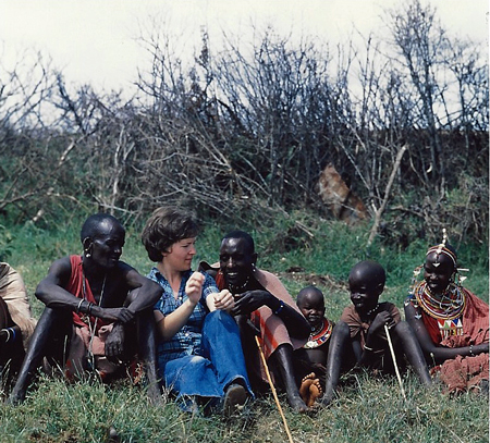 A tourist in Kenya is visiting a Maasai tribe.