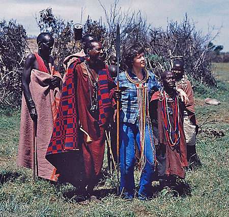A tourist in Kenya is visiting a Maasai tribe.
